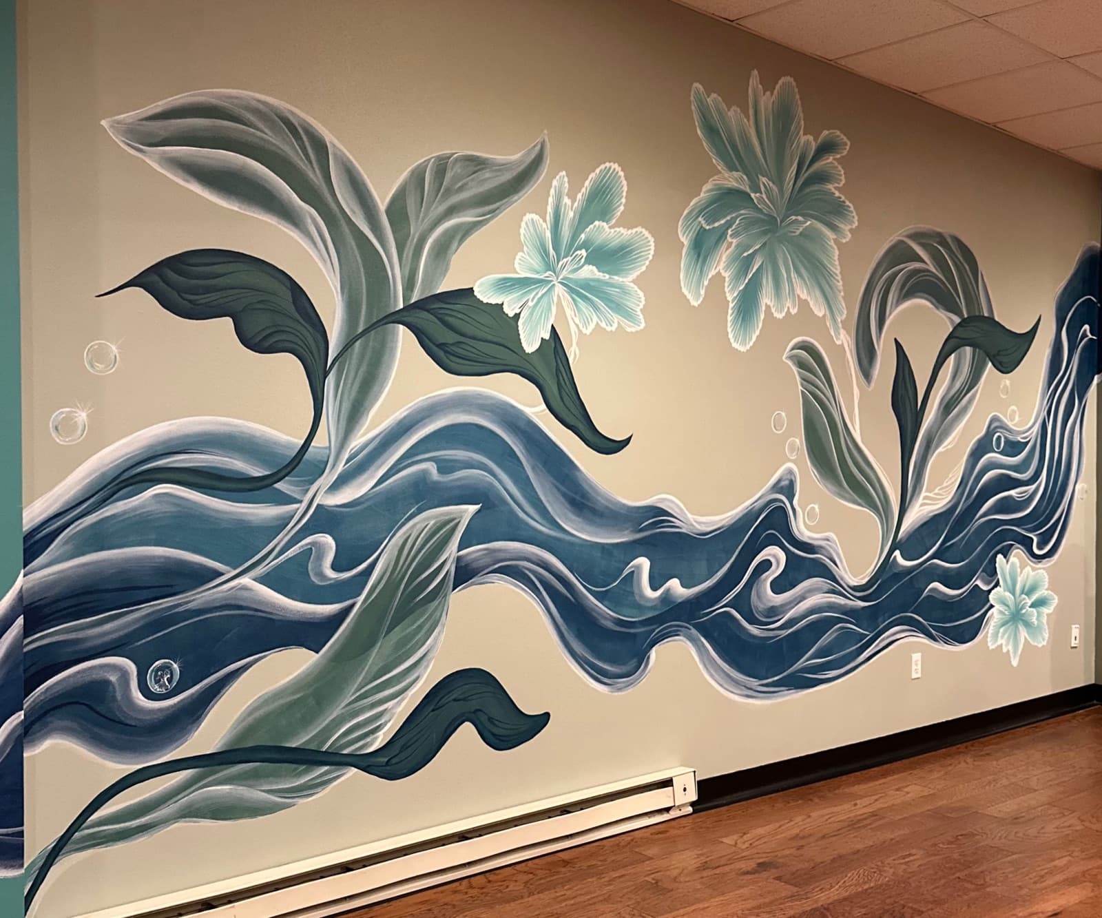 A hand-painted mural of flowing blue ribbons, leaves, and florals along a reception hallway wall